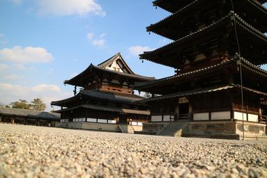 Ancient pagodas made of wood, standing on a ground of small stones