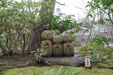 a group of stone statues in a garden